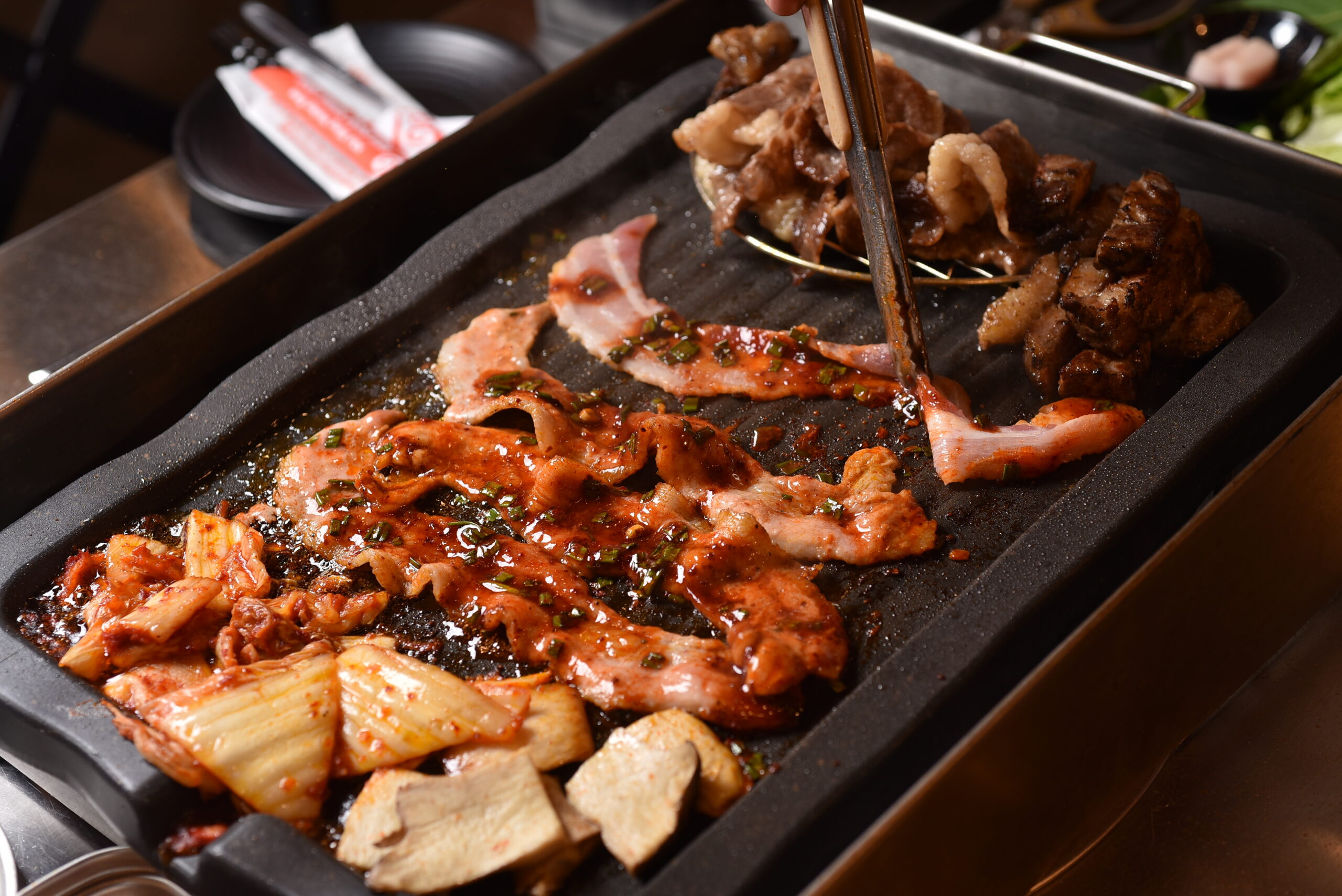 Korean BBQ pork and kimchi grilling at Nướng Rơm in Da Nang