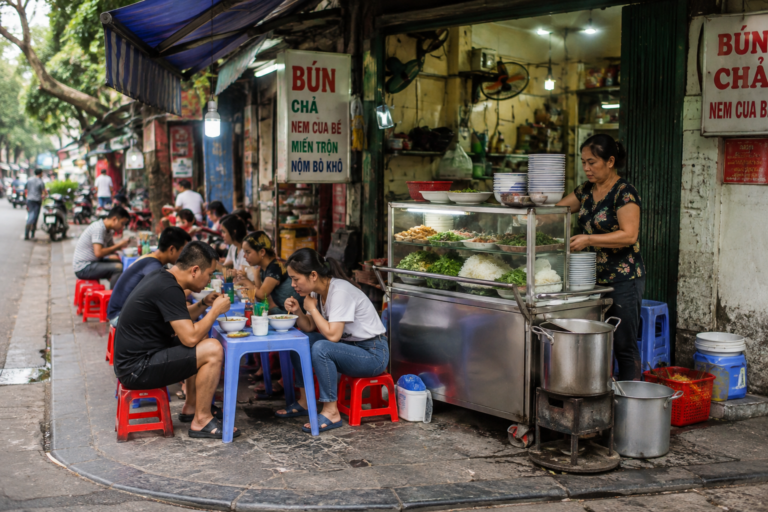Small Vietnamese street food stall with plastic tables and stools